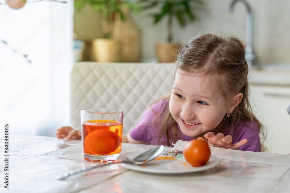 Preparing for Easter. A cute little girl sits at a table and paints eggs. Preparing for Easter. A cute little girl sits at a table and paints eggs.