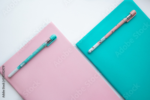 colorful notebooks and pens on a white background
