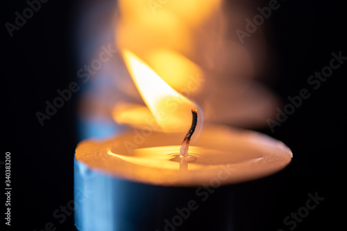 Several candles burning in a row. Photographed close-up.