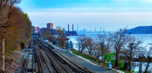 Waterfront view in Hastings-On-Hudson, NY, with train tracks and the Hudson River and New York City in the background