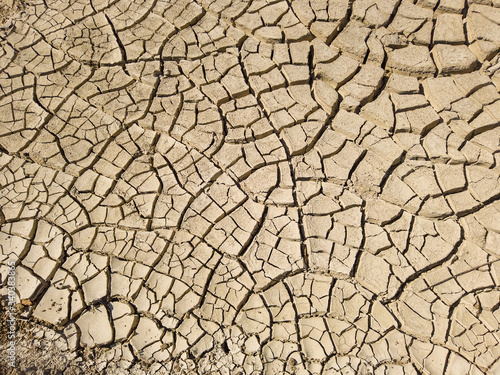 Overhead top view of dry arid soil with cracks during intense heat. Lack of water on agriculture field. Concept of global warming.