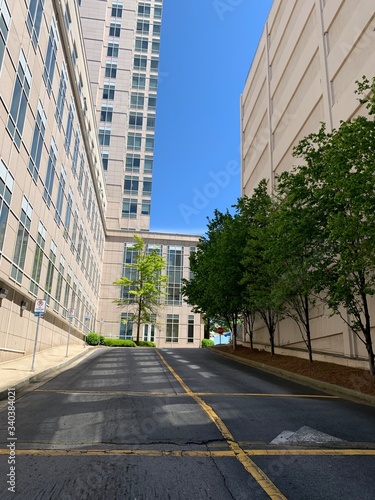 Uphill road between two buildings with landscaping 