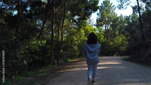 Wallpaper Mural Child walking through a forest or a park with green leaves and sun shining through the foliage Torontodigital.ca