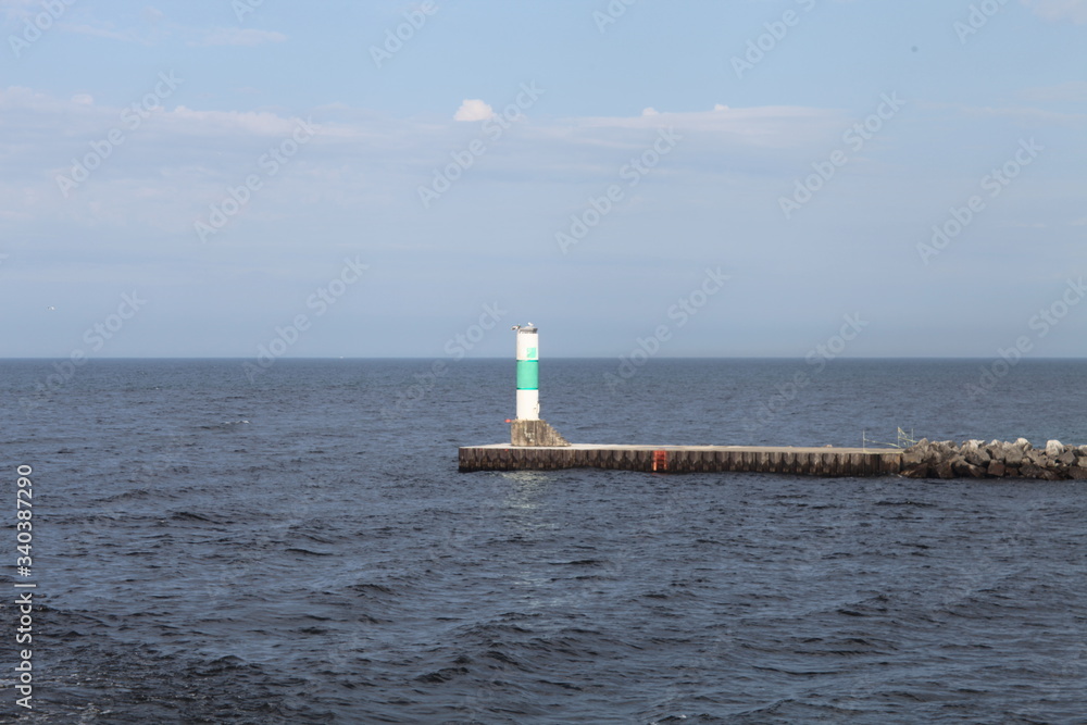 SUMMER DAY, WITH A LIGHTHOUSE ON THE LAKE, BLUE SKY, AND BLUE WATER SUMMER DAY, WITH A LIGHTHOUSE ON THE LAKE, BLUE SKY, AND BLUE WATER