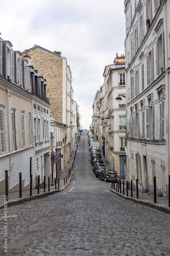 Vertical view of a desertic street with a stoned road in Montmartre quarter of Paris, France