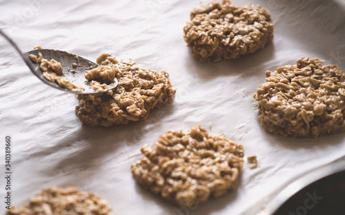 paleo dessert, homemade cookies made of oatmeal and banana . Low carb diet recipes. less sugar consumption. spoon and raw dough on baking sheet.