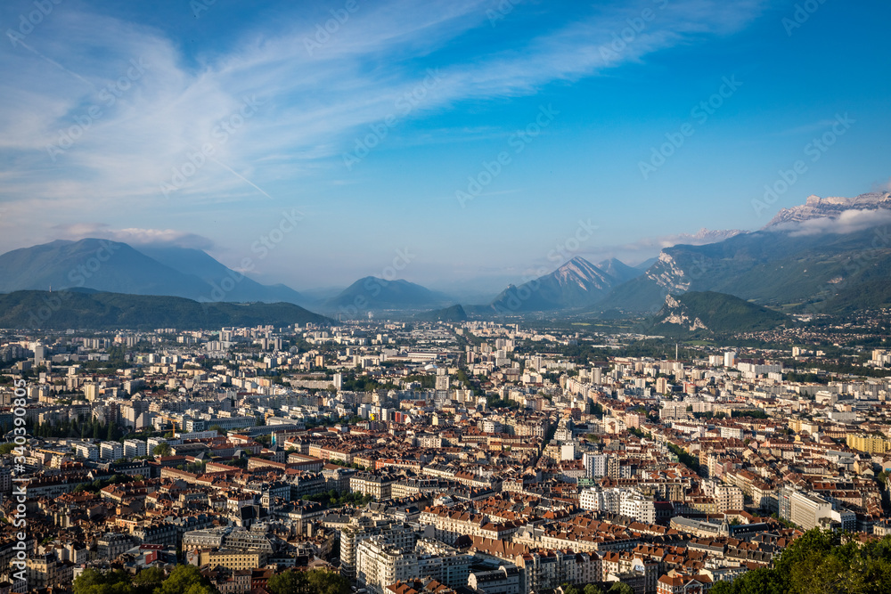 Wispy clouds over Grenoble france on a sunny day with lots of blue sky and mountains