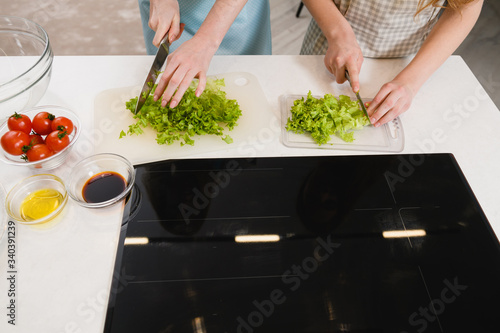Hands cut greens for salad at home
