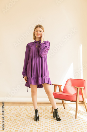 Wallpaper Mural Winsome girl in romantic attire pretty smiling on beige background. Slim female model in dress looking to camera with shy face expression. Torontodigital.ca