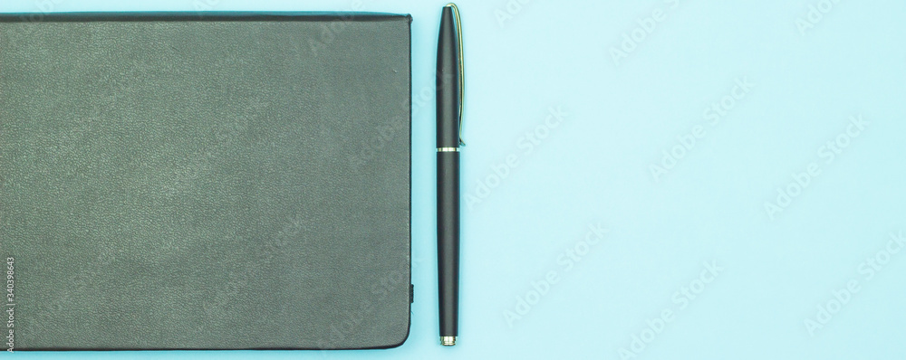 Closeup image of organizer and pen. Isolated on blue background