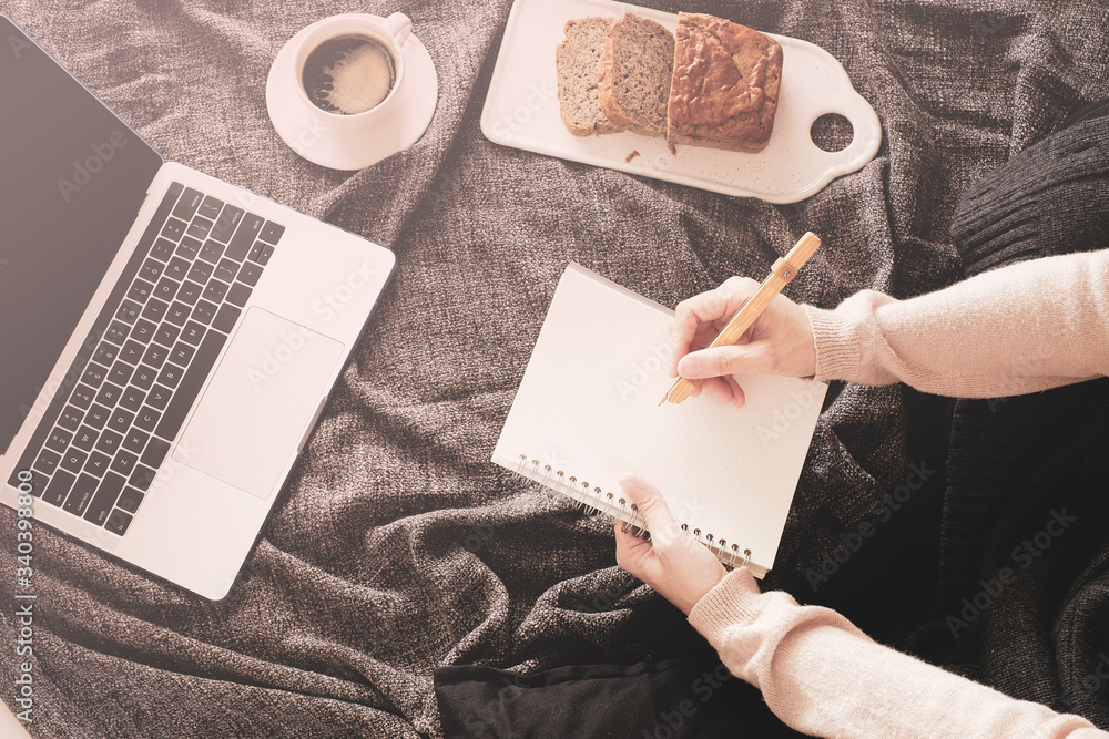 Obraz premium woman work at home for stay home order of coronavirus pandemic .online working and learning on bed with the laptop, mobile phone and good vibe.