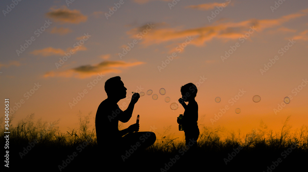 Father son playing in the park blowing bubbles. Family lifestyle concept.  