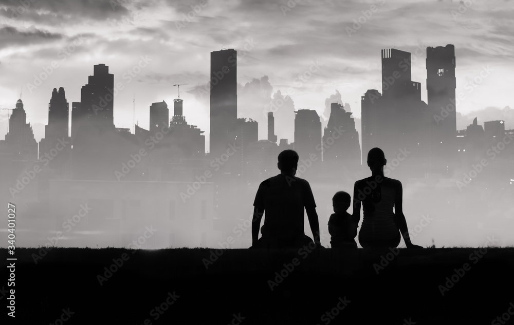 Φωτογραφία Silhouette of family sitting in city park looking at the city skyline