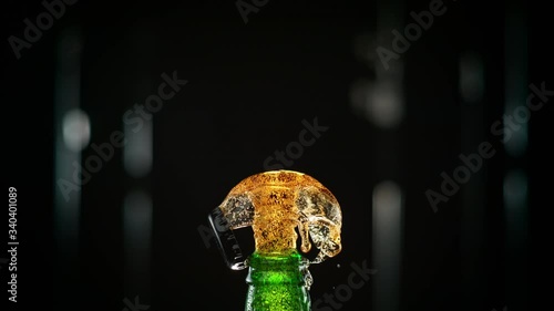 Macro Shot of a Cap Popping off the Green Bottle and Golden Carbonated Beer Splash Explosion. Phantom Flex 1000fps photo