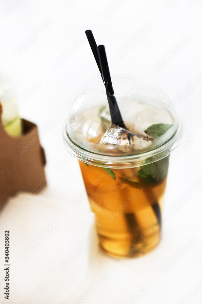 ice tea in plastic cup with black straws on the table with cup holder ice tea in plastic cup with black straws on the table with cup holder