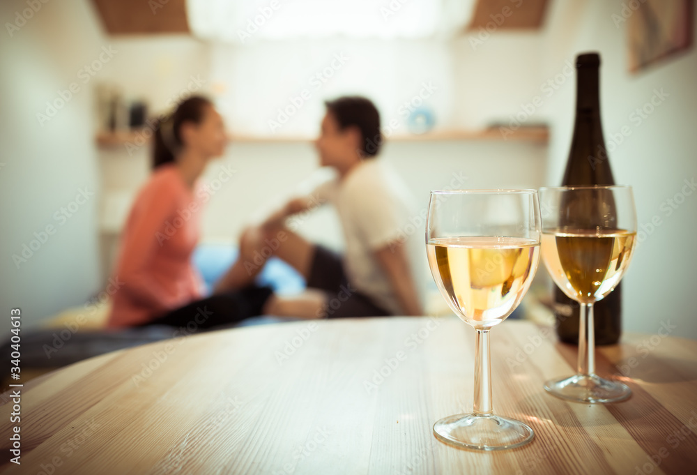 Mana woman couple taking together enjoying relaxing  time at home with glass of wine. 