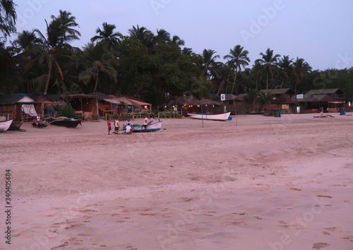 Locals gather by a fishing boat on the deserted Agonda beach to discuss the latest news during the Coronavirus lockdown in Goa
