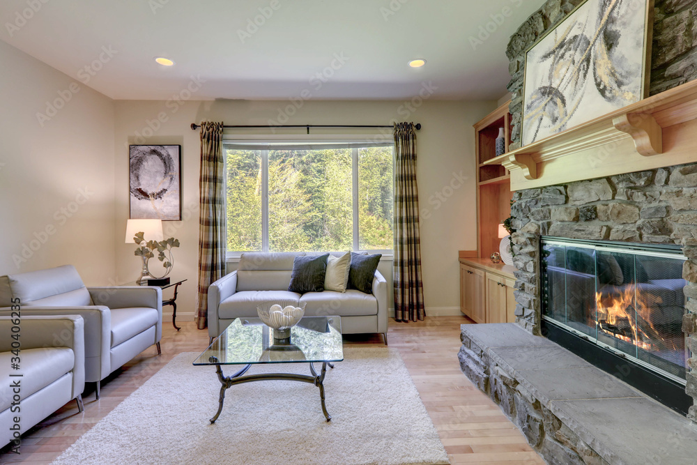 Living room with stone fireplace and light hardwood floor and sliding door to the back yard. Living room with stone fireplace and light hardwood floor and sliding door to the back yard.