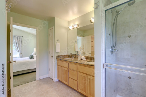 Large classic master bedroom bathroom with walkin in shower  buil in tub and wood cabinets with two sinks.