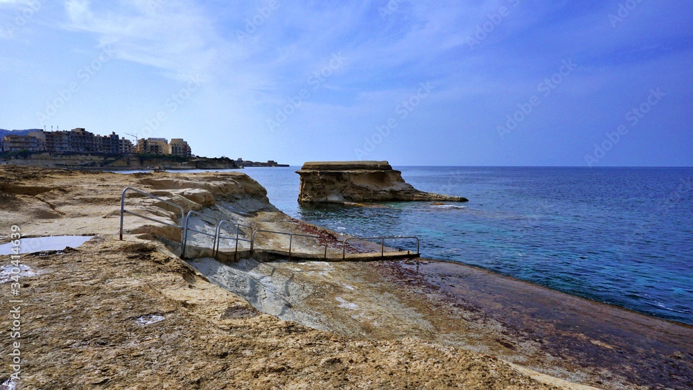 Stony coastline with swimming area at the Marsalforn Village in Gozo Island, Malta 