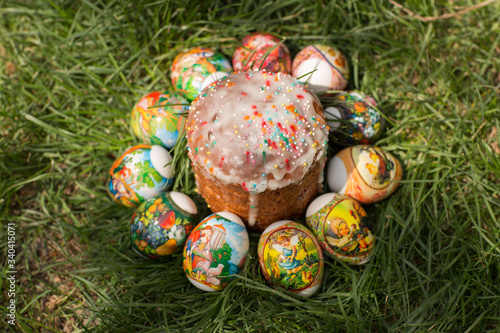  Easter bread and eggs with different patterns on green grass. Top View.