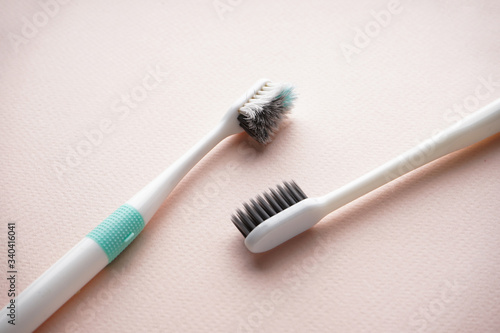 New and old toothbrushes on a beige background  close-up  flat lay.