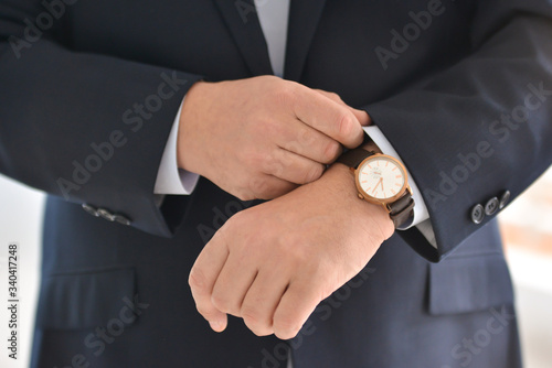 Correct wristwatches on hands close-up, dressing, man's style, stylish man. Businessman luxury style. Elegant young handsome man. Men's jacket, hand cover the button. Business style.