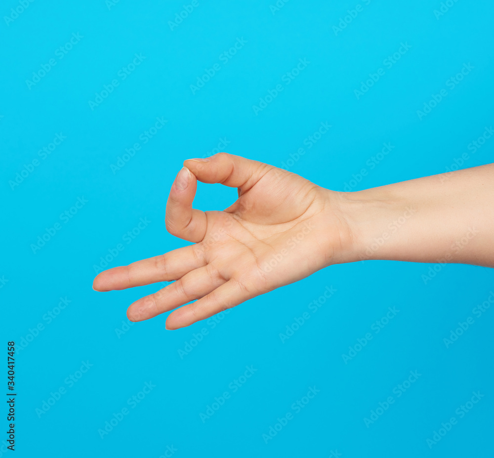 female hand shows the mudra of Knowledge on a blue background