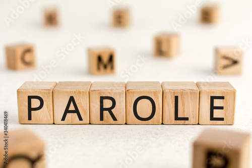 Parole - word from wooden blocks with letters, parole concept, random letters around white background