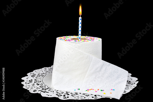 birthday candle in roll of toilet paper on lace paper doily with candy confetti sprinkles