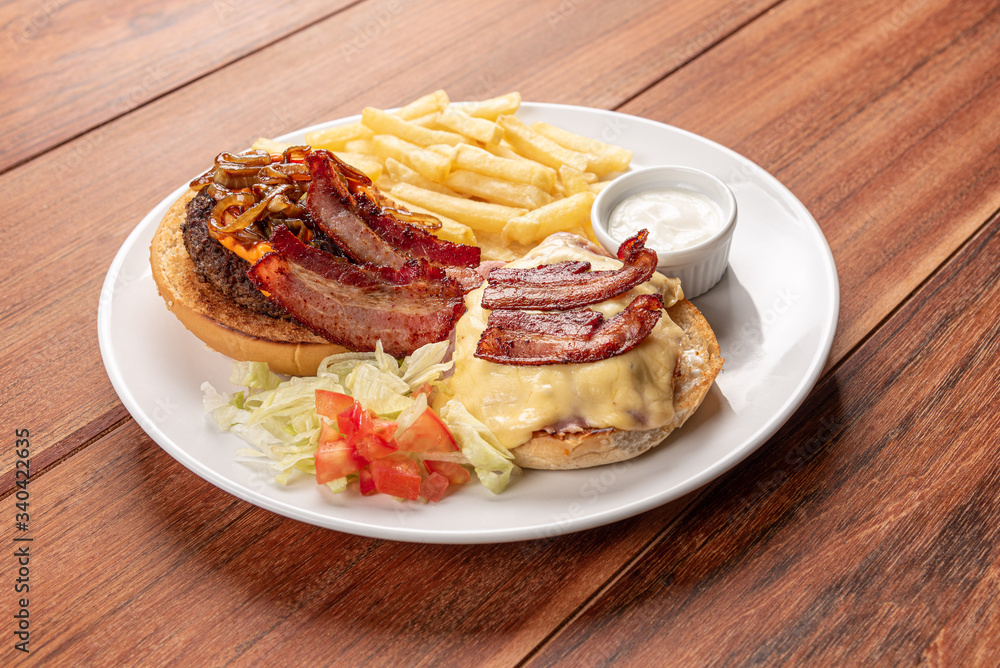 Fresh burger closeup on wooden table with potato fries. Delicious cheeseburger. Home made hamburger with beef, bacon and cheese. Fresh burger closeup on wooden table with potato fries. Delicious cheeseburger. Home made hamburger with beef, bacon and cheese.