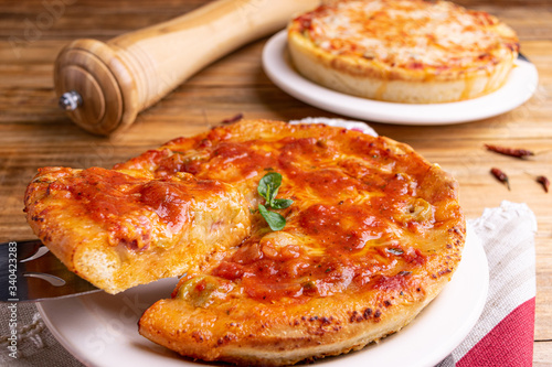 Chicago Style Deep Dish Cheese Pizza with Tomato Sauce, on wooden background