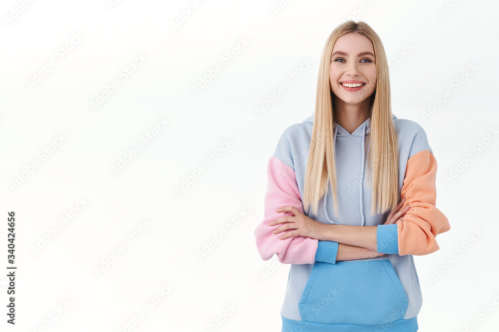 Youth, education and people concept. Portrait of cheerful blond teen girl, looking confident, cross arms over chest and smiling pleased, self-assured, wearing hoodie, standing white background Youth, education and people concept. Portrait of cheerful blond teen girl, looking confident, cross arms over chest and smiling pleased, self-assured, wearing hoodie, standing white background