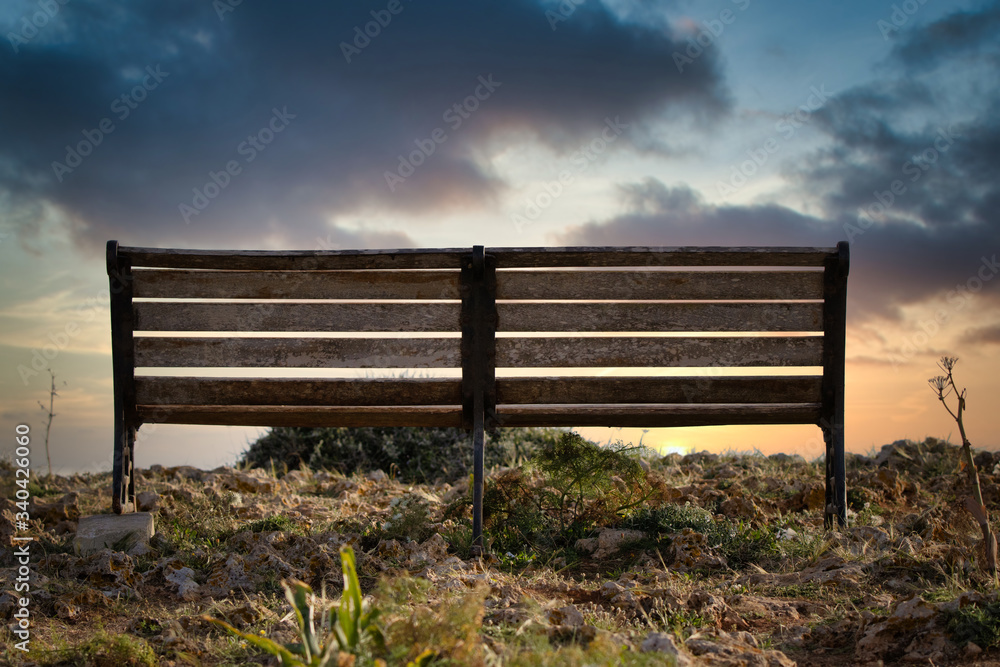 A bench in front of a sunset A bench in front of a sunset