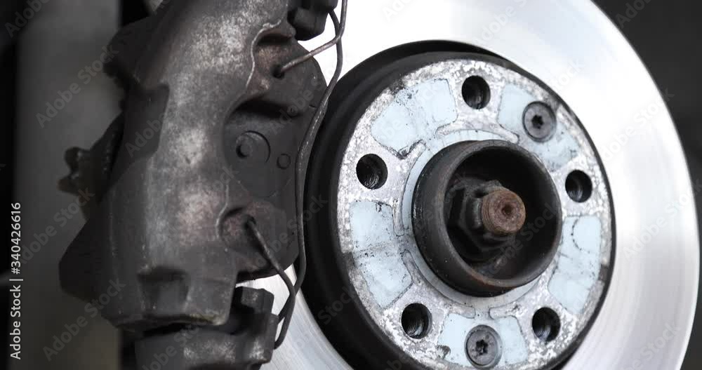 At the car mechanic showing the disc brakes-backing plates and brake pads on a car-the shot is slightly moving At the car mechanic showing the disc brakes-backing plates and brake pads on a car-the shot is slightly moving