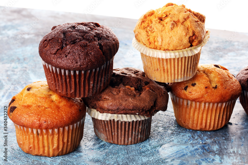 Chocolate muffin and nut muffin, homemade bakery on background.