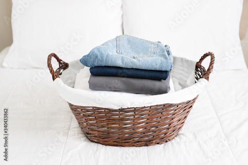 Wicker laundry basket with neatly folded clothes