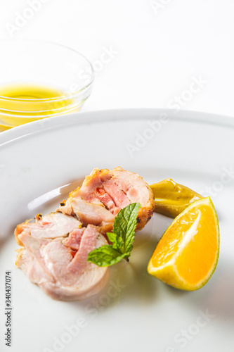Stuffed chicken rolls on a white plate with mustard