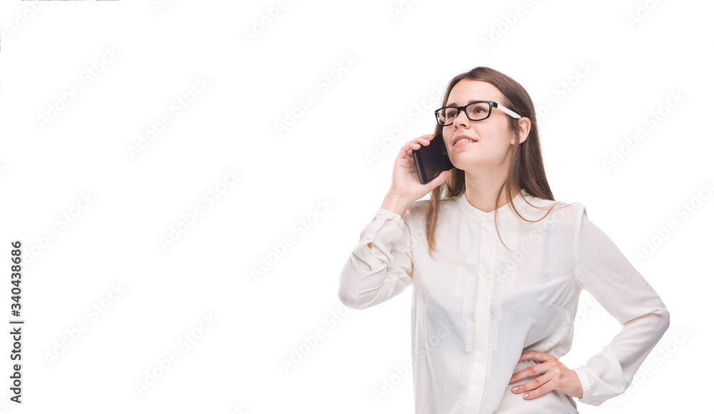Smiling businesswoman in glasses talking on mobile phone. Beautiful young girl in white shirt on white isolated background talking on mobile phone. Woman in shirt with cellphone. Copy space. Blank Smiling businesswoman in glasses talking on mobile phone. Beautiful young girl in white shirt on white isolated background talking on mobile phone. Woman in shirt with cellphone. Copy space. Blank