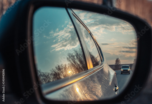 Reflection of the road in the mirror of a car closeup.