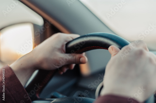 Closeup guy hand on car steering wheel