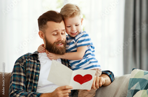 Little boy giving greeting card to dad.