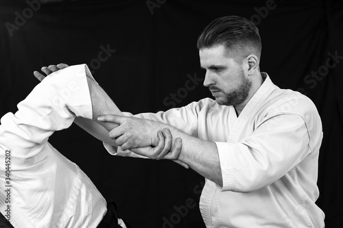 Close-up of a young man doing a painful hand technique from aikido technique