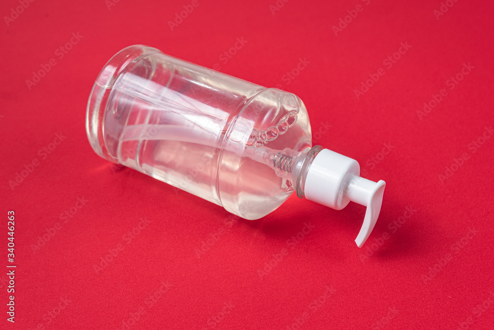 Container with alcohol gel on the red background Container with alcohol gel on the red background
