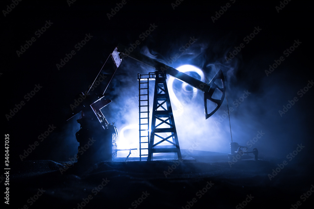 Oil pump and oil refining factory at night with fog and backlight. Energy industrial concept. Selective focus.