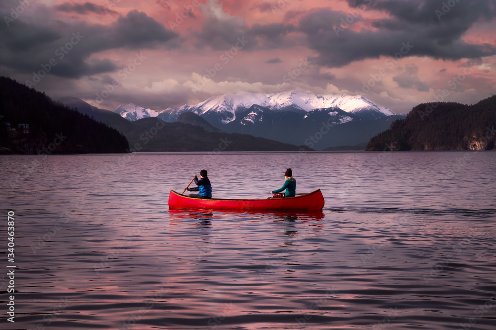 Fantasy Image Composite of Adventurous People on a Wooden Red Canoe during a Pink Cloudy Sunset. Landscape from Harrison Lake, British Columbia, Canada.
