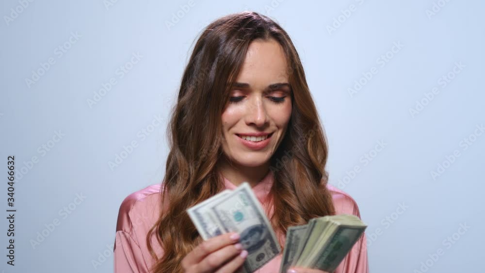 Businesswoman counting money on blue background. Woman holding cash in studio Businesswoman counting money on blue background. Woman holding cash in studio