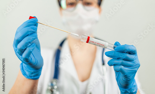 Test for coronavirus Covid-19. Female doctor or nurse doing lab analysis of a nasal swab in a hospital laboratory. photo