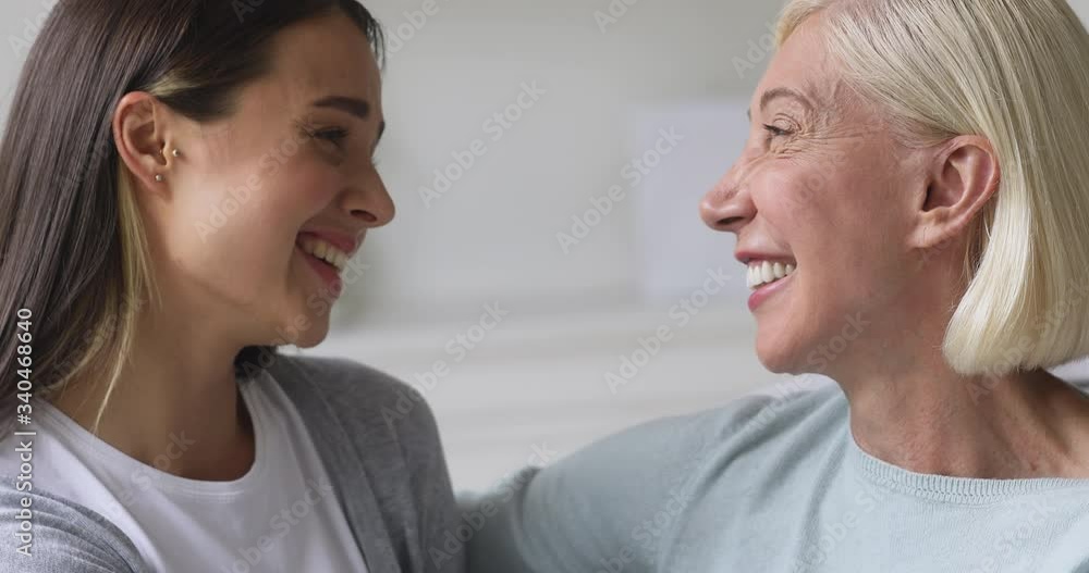 Head shot close up happy young attractive woman looking at camera with older mommy. Pleasant middle aged mother having fun laughing with grown up daughter, looking into eyes, touching foreheads. Head shot close up happy young attractive woman looking at camera with older mommy. Pleasant middle aged mother having fun laughing with grown up daughter, looking into eyes, touching foreheads.