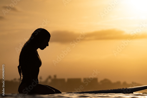 silhouette of a woman surfing in the ocean © Stepan